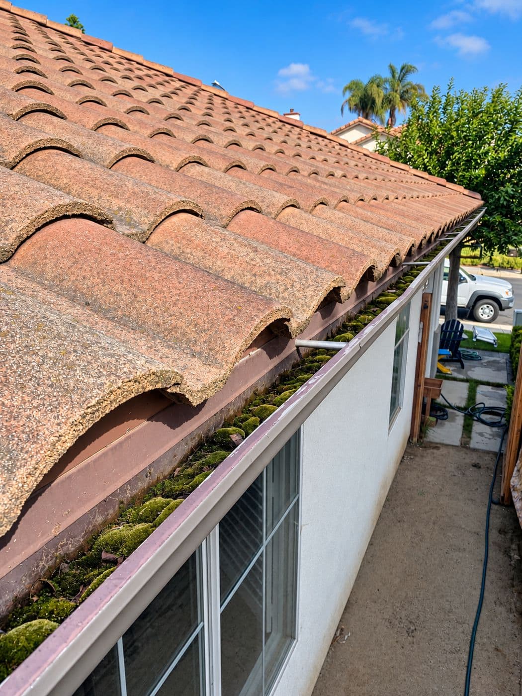 A cleared gutter below a clay tile roof