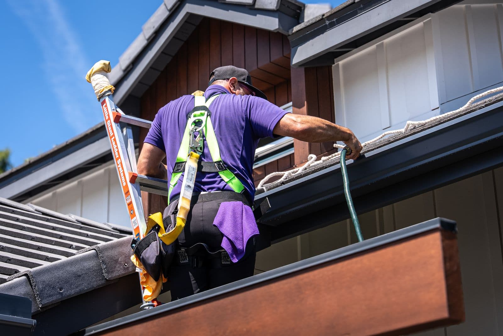 Gutter cleaning from a ladder at the roofline