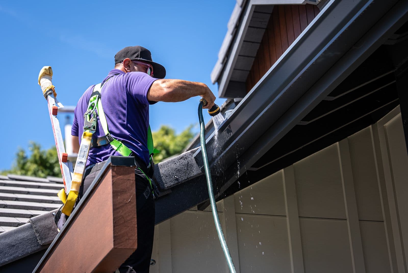 RadPad technician hose-flushing a gutter run