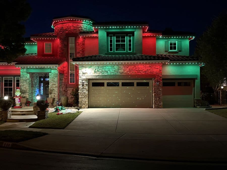 Red and green holiday lighting on a two-story home