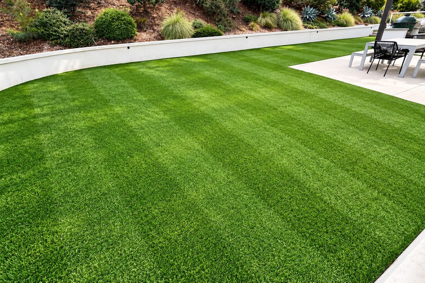 Groomed artificial turf with even stripes in a backyard
