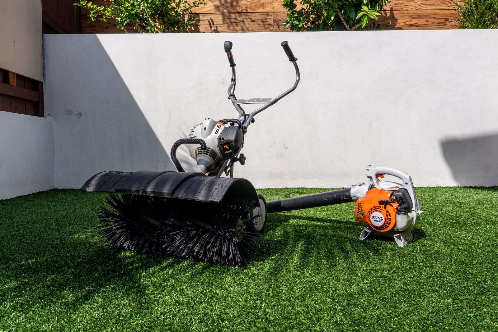 Power broom and blower staged for artificial turf maintenance