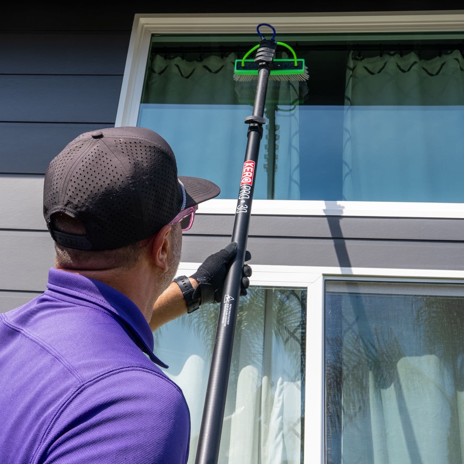 RadPad technician reaching a second-story window with an extension pole